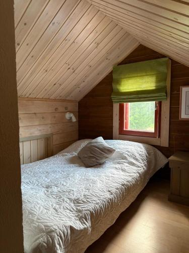 ein Bett in einem Holzzimmer mit Fenster in der Unterkunft Aurora Lodge in Rovaniemi