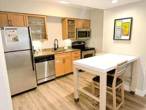 a kitchen with a white table and a refrigerator at Sonesta ES Suites Cincinnati - Sharonville West in Sharonville