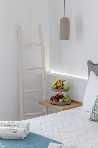 a bedroom with a bed and a plate of fruit on a table at Margaret of Naxos in Agios Prokopios
