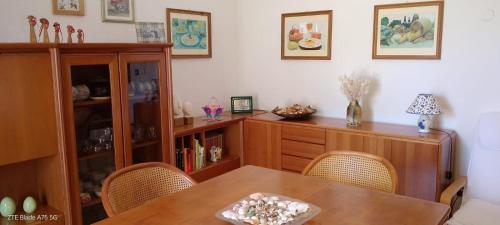 a dining room with a wooden table and chairs at Appartamento vicino al mare in Lizzano