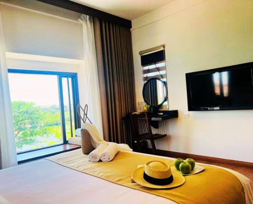 a hotel room with a bed with towels and hats on it at Happy Life Memories Hoi An Hotel & Spa in Hoi An