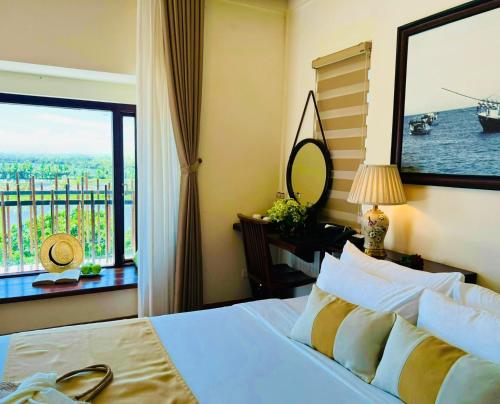 a bedroom with a bed with a view of the ocean at Happy Life Memories Hoi An Hotel & Spa in Hoi An