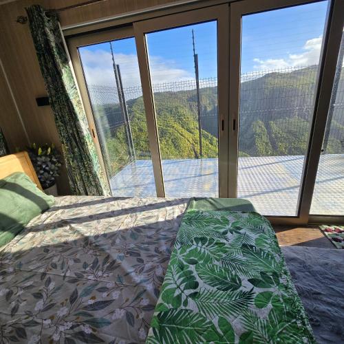 a bedroom with a bed and a large window at Green Discovery's Birds' Nests in Henrietta