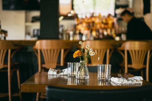 a wooden table with a vase of flowers on it at MacTaverne in Val-David