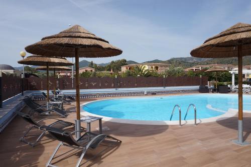 a swimming pool with chairs and umbrellas at Hotel Il Platano in San Teodoro