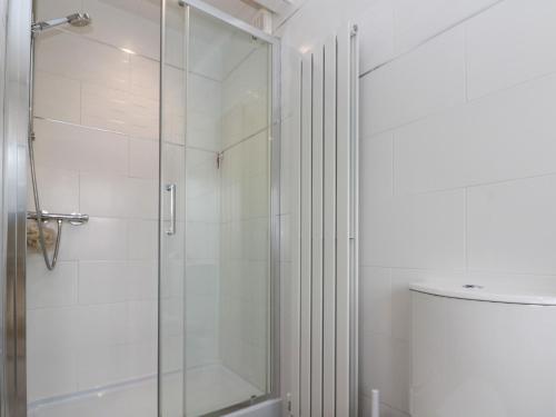 a bathroom with a glass shower with a toilet at Christlow Cottage in Bridlington