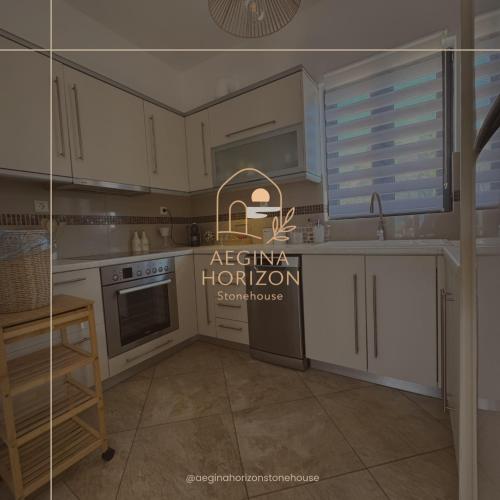 a kitchen with white cabinets and a sign that says asiana horizons at Aegina Horizon Stonehouse No I in Aegina