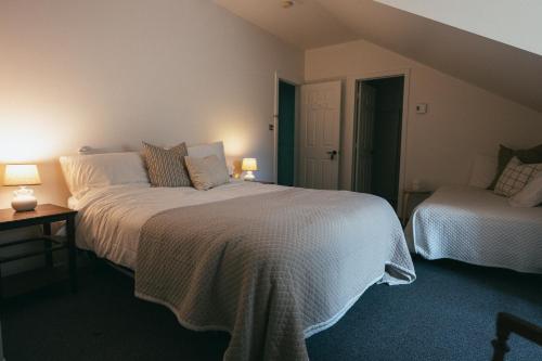 a bedroom with two beds and two lamps at MacTaverne in Val-David