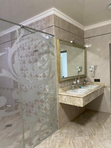 a bathroom with a sink and a shower at Aq-Jaiyq Halal Hotel in Karagandy