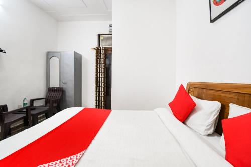 a bedroom with a bed with red and white pillows at Hotel O Devi Palace Inn in Gurgaon