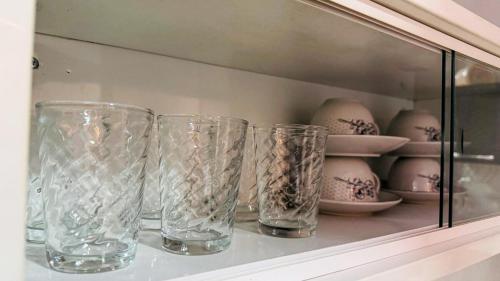 four glass vases sitting on a shelf in a cabinet at BOX 360 - Container SUSPENSO! in Uberlândia