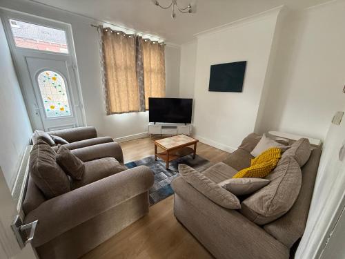 a living room with two couches and a flat screen tv at Leeds Serviced Accommodation - Apartments - 3 Bed House-Close To Centre -M621 & M1 - Contractors - Business Travellers - Families in Beeston