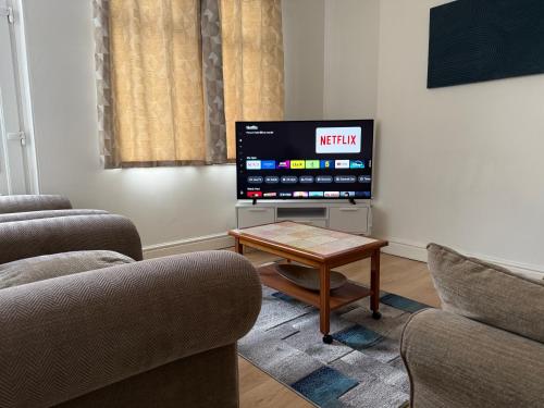 a living room with a tv and a coffee table at Leeds Serviced Accommodation - Apartments - 3 Bed House-Close To Centre -M621 & M1 - Contractors - Business Travellers - Families in Beeston
