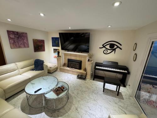 a living room with a couch and a piano at Illuminati Guest House in Victoria
