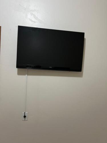 a flat screen tv hanging on a wall at Suíte privativa in Novo Hamburgo