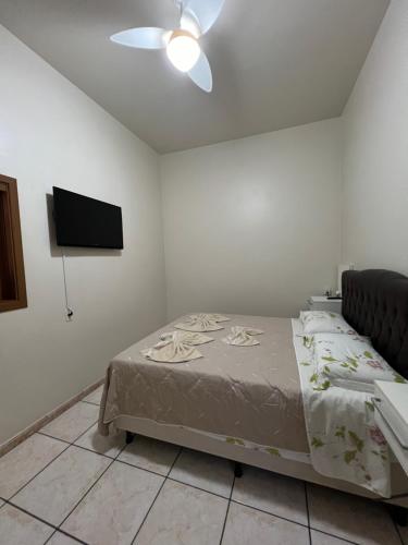a bedroom with a bed and a flat screen tv at Suíte privativa in Novo Hamburgo