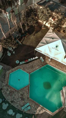 an overhead view of a swimming pool with blue water at Pousada Cabo Frio in Cabo Frio