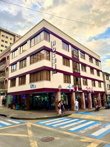 a building on a street with people walking in front of it at Hotel Pereira Central in Pereira