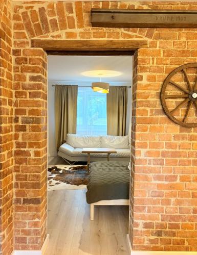 a living room with a brick wall and a couch at Apartamenty Zloty Pociąg in Boguszów-Gorce