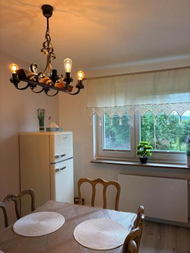 a kitchen with a dining room table and a window at Apartamenty Zloty Pociąg in Boguszów-Gorce