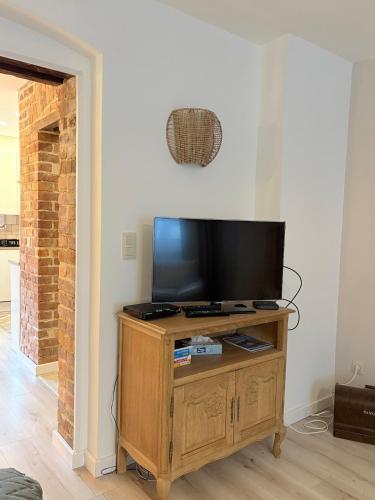 a flat screen tv sitting on top of a wooden entertainment center at Apartamenty Zloty Pociąg in Boguszów-Gorce