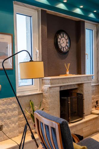 a living room with a fireplace and a clock at μεThea Rooftop Apartment in Alexandroupoli
