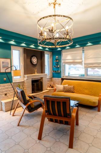 a living room with a couch and a chandelier at μεThea Rooftop Apartment in Alexandroupoli