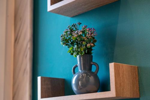 a vase with flowers in it sitting on a shelf at μεThea Rooftop Apartment in Alexandroupoli