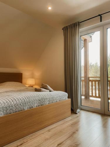 a bedroom with a bed and a large window at Kasi Polany in Polany