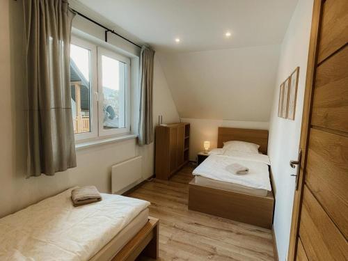 a small bedroom with two beds and a window at Kasi Polany in Polany
