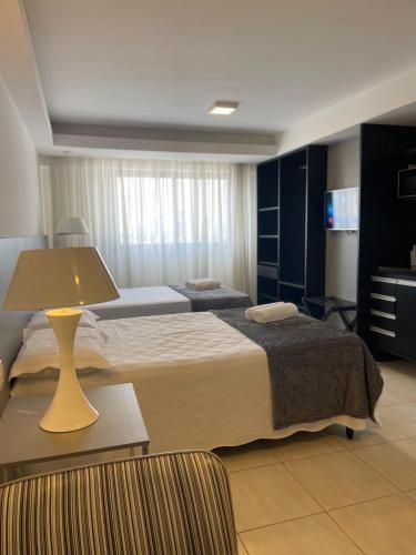 a hotel room with two beds and a lamp at EXECUTIVE 05 · Suíte Premium de alto padrão V- Climatizado in Feira de Santana