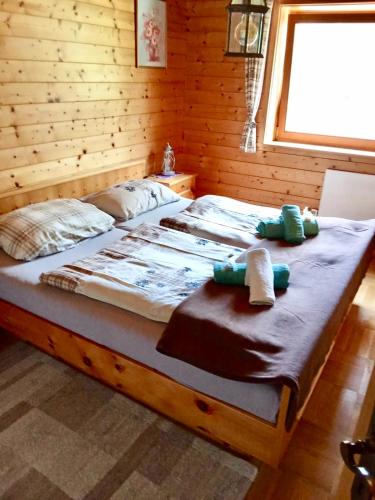 a bed in a wooden room with towels on it at Almhaus Zirbenheim Nicolina in Flattnitz