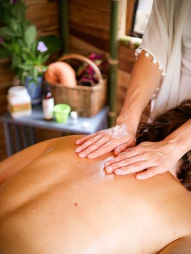 a woman getting a back massage at a spa at Essence Arenal Spa & Yoga in El Castillo de La Fortuna