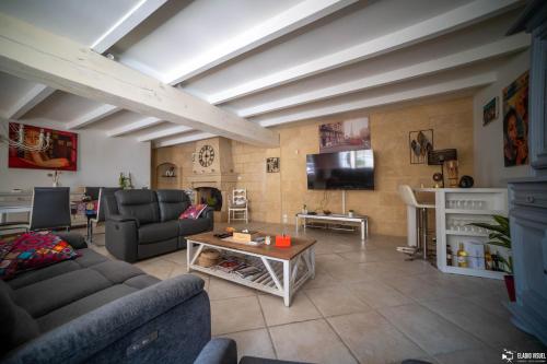 ein Wohnzimmer mit Couch und Tisch in der Unterkunft Le Patio Olea in Montfrin