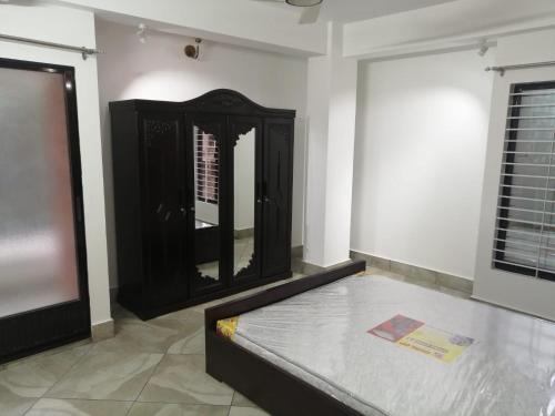 ein Zimmer mit einer schwarzen Kommode und einem Spiegel in der Unterkunft The Abode- SUST Gate in Sylhet