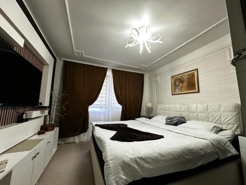 a bedroom with a large bed and a chandelier at Vila CITY by BEN&CO in Sarajevo