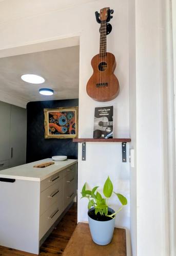 a kitchen with a guitar on the wall and a plant at Blue Mountains Urban Farm Stay near Sydney in Hazelbrook