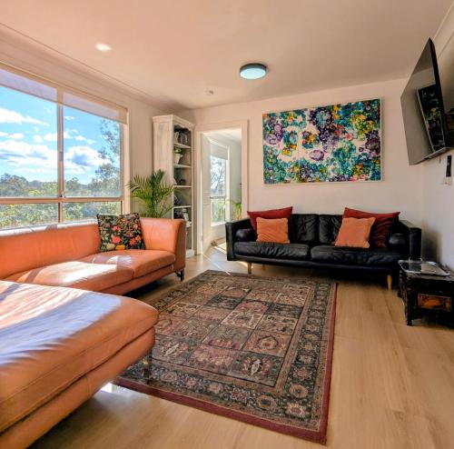 a living room with two couches and a rug at Blue Mountains Urban Farm Stay near Sydney in Hazelbrook