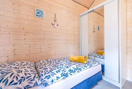 a bedroom with a bed with a teddy bear on it at Domki Bursztynowy Resort in Jarosławiec