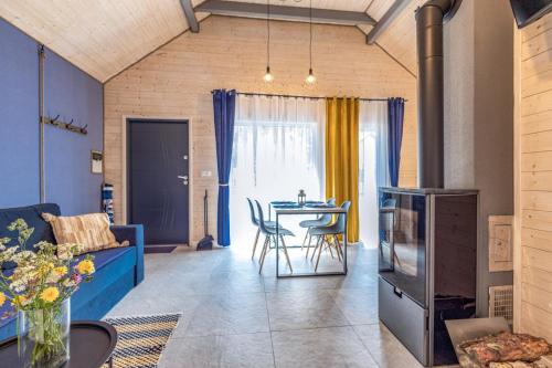a living room with a blue couch and a table at Domki Bursztynowy Resort in Jarosławiec