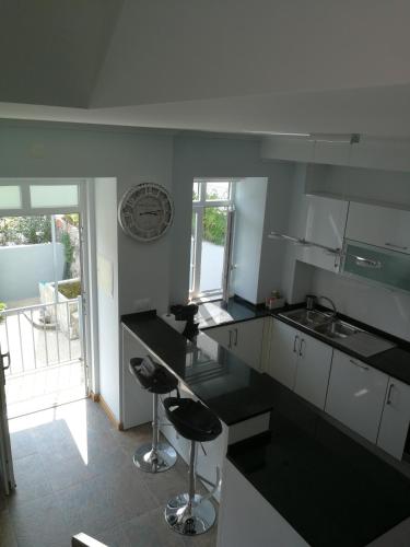 a kitchen with black counter tops and stools at Casa Manuel in Manteigas
