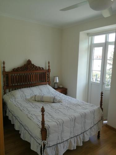 een slaapkamer met een groot bed met een houten hoofdeinde bij Casa Manuel in Manteigas