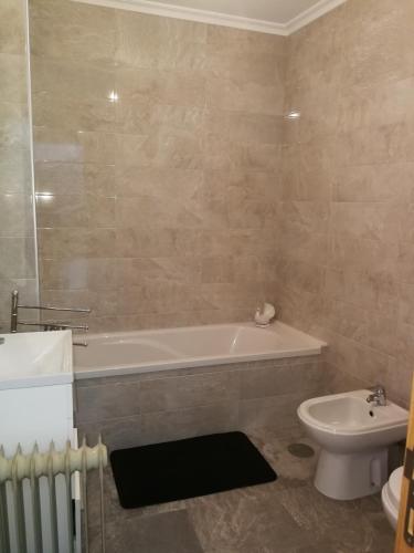 een badkamer met een bad, een toilet en een wastafel bij Casa Manuel in Manteigas