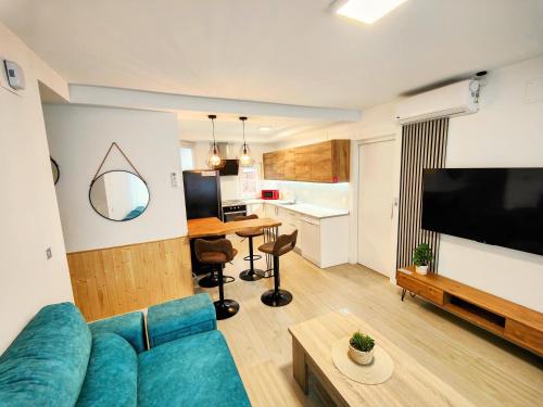 a living room with a blue couch and a kitchen at El Andén de Garrido sin ascensor in Salamanca