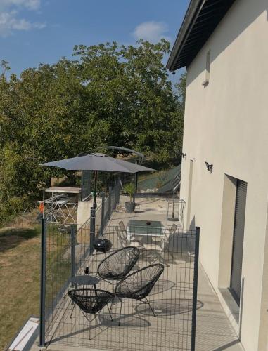 a patio with a table and chairs and an umbrella at Villa Bellevue in Belley