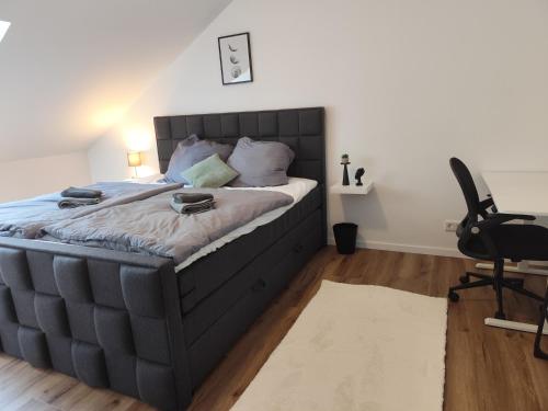 a bedroom with a large bed and a desk at Familienfreundliche DGW in ruhiger Lage für 4 Personen - Waschtrockner, Arbeitsplatz, Balkon und Gartennutzung in Aschaffenburg