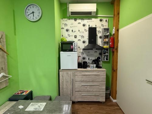 a kitchen with green walls and a clock on the wall at Stern in Hückelhoven