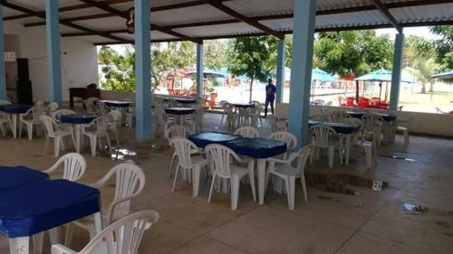 a group of tables and white chairs and blue tables at O Cantinho da Patricia e Tony in Macaíba