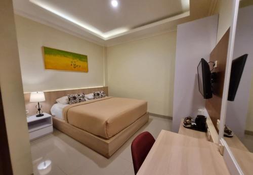 a hotel room with a bed and a television at Omah Nayan Guest House in Seturan