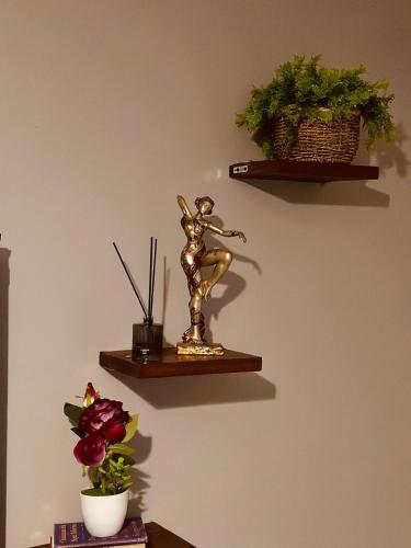 a statue of a woman holding a bat on a wall at Kylo cozy calm in Kampala